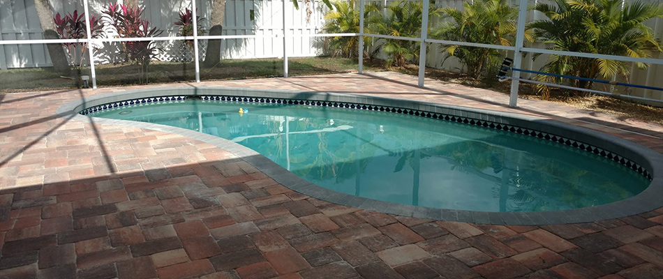 Paver patio installed beside pool in New Port, FL.