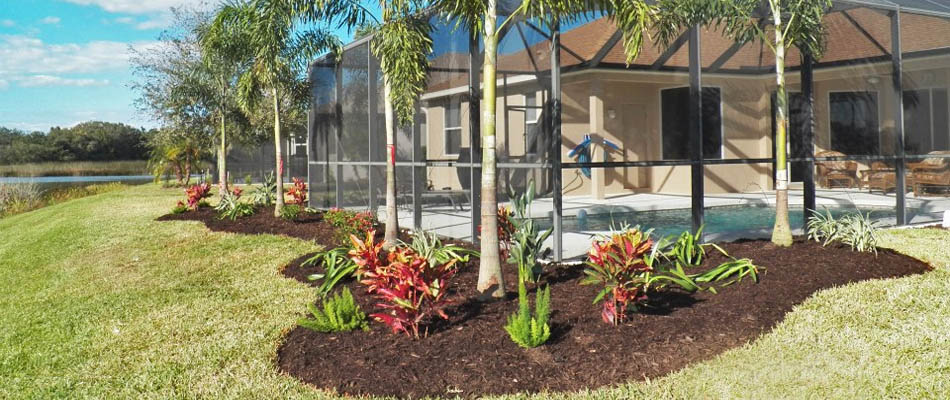 Anna Maria, FL property with freshly designed landscape beds and palm trees.